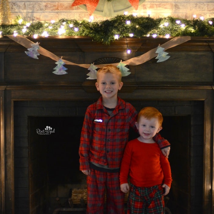 Kids proudly hanging their Christmas tree banner