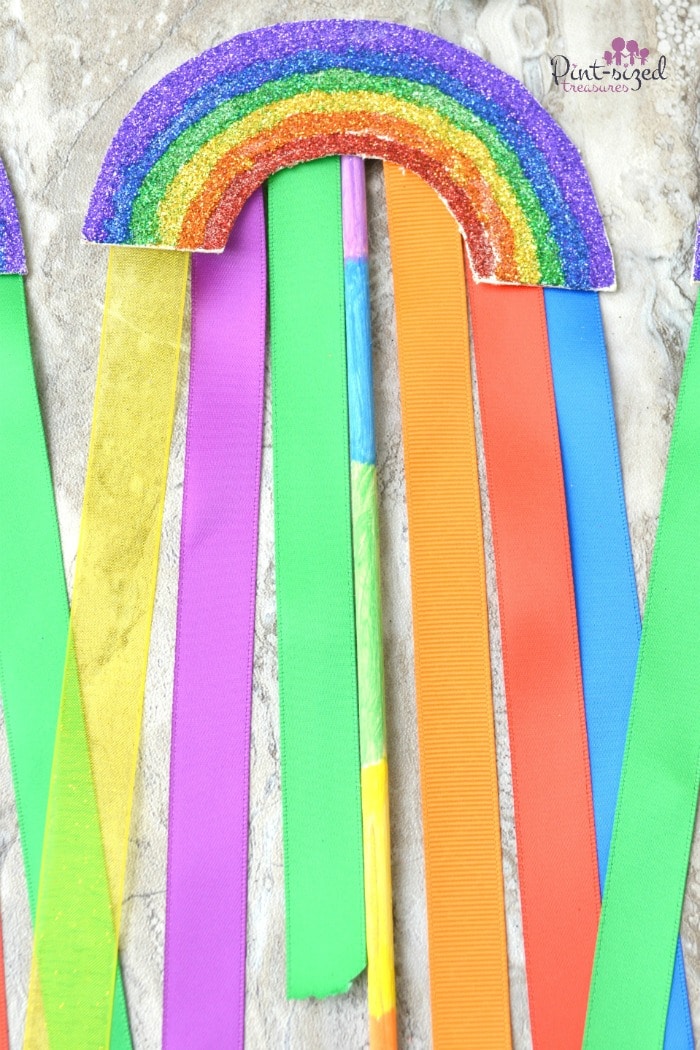 Super simple rainbow wands are made with thick paper, ribbons and paint! Super simple craft forbids who love rainbows! #rainbowcraft #rainbowwand #pretendplay #wandcraft #StPatricksDay #craftsforkids #easyrainbowcraftsforkids