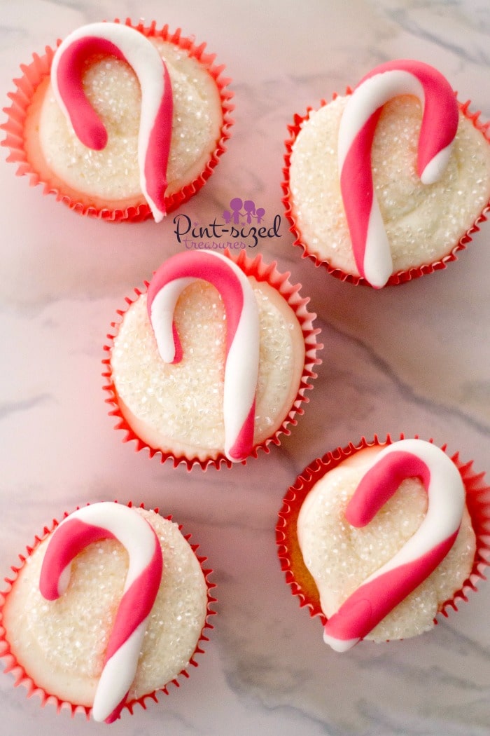 These adorable candy cane cupcakes are made using fondant and a cake mix! Easy, but super-cute for Christmas! #cupcakes #candycanes #Christmascupcakes #holidayrecipes #holidapcupcakes #candycanecupcakes #candycanetreats