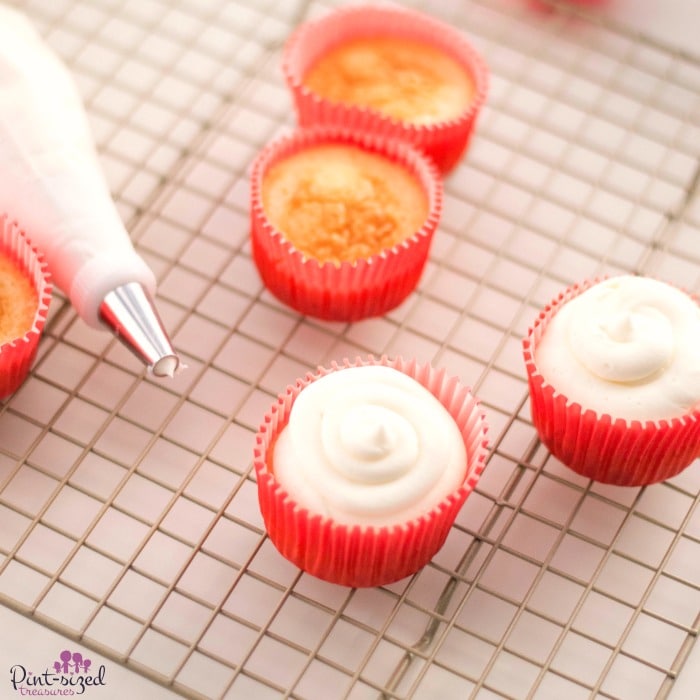 Piping the frosting on the candy cane cupcakes