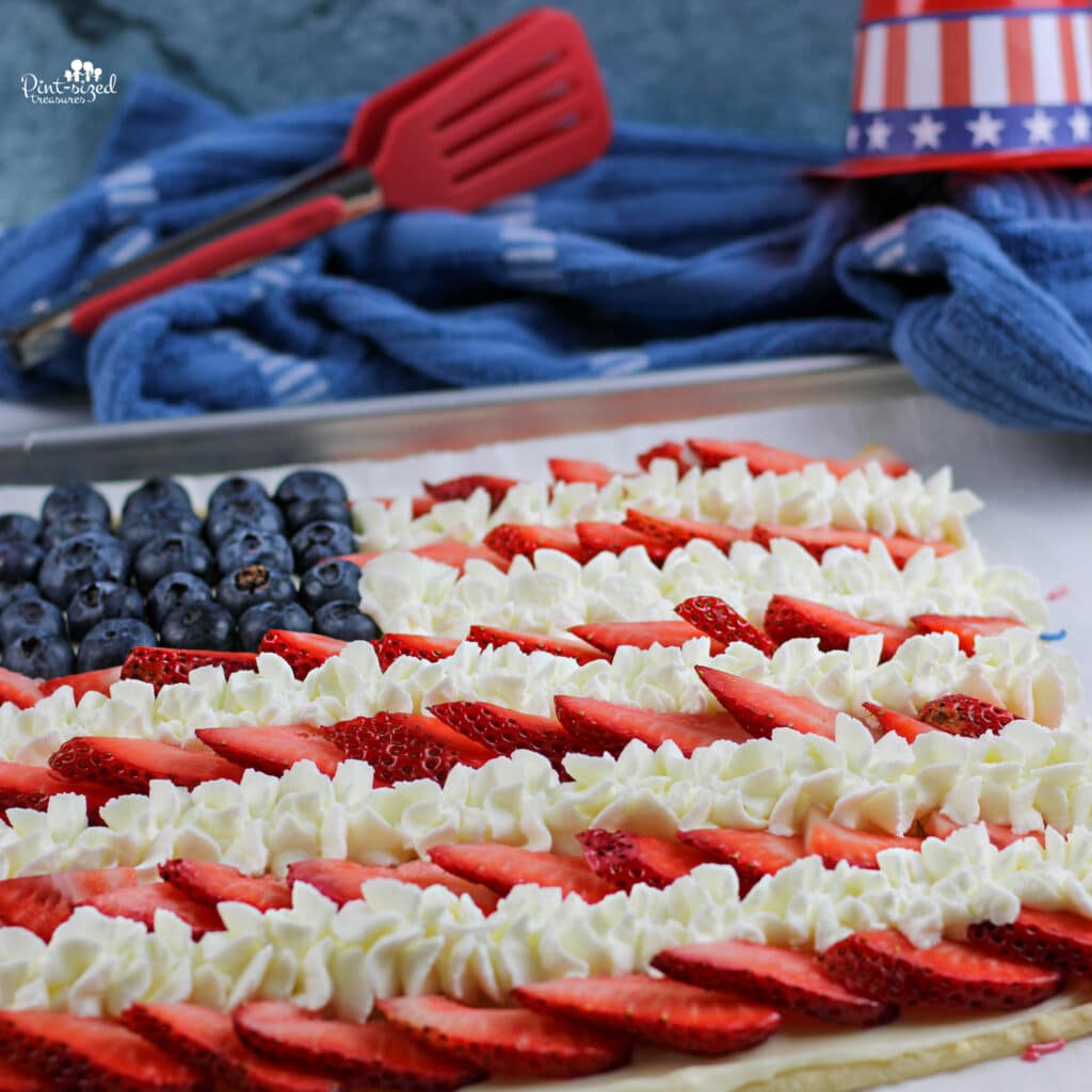 American flag fruit pizza with whipped cream, blueberries, and strawberries