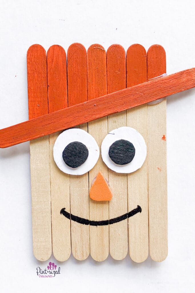 gluing the popsicle sticks together for the scarecrow craft