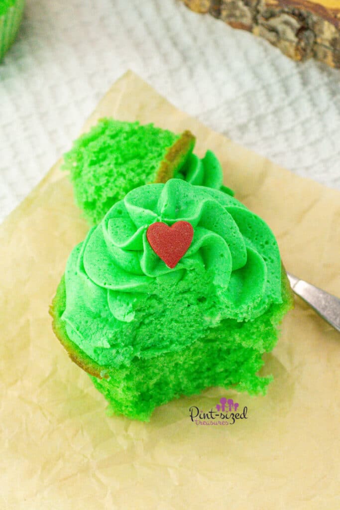 taking a bite of a green Grinch cupcake