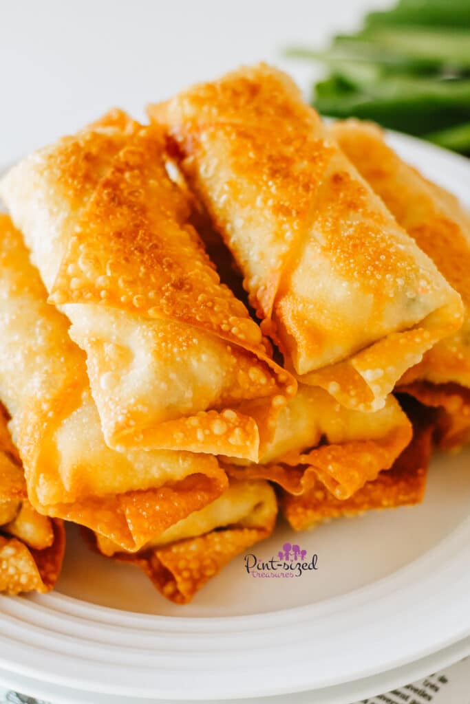 crab rangoon egg rolls stacked on a plate