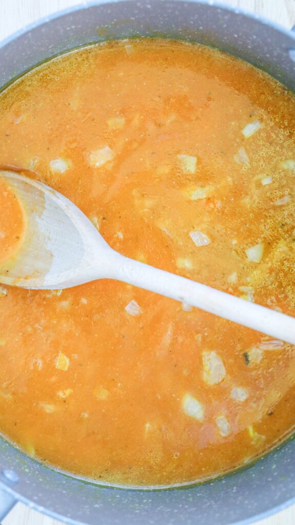 adding ingredients to creamy pumpkin soup